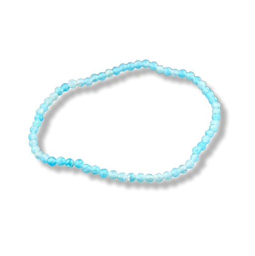 A beaded stretch bracelet made of light blue and white faceted beads, arranged in an oval shape on a white background with a soft drop shadow.