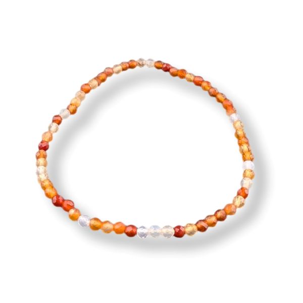 A beaded bracelet made of small faceted beads in orange, red, white, and translucent clear, arranged in a circle on a white background.