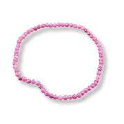 A stretch bracelet  of faceted ruby beads arranged in a loose circle on a white background.