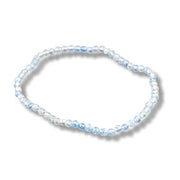 A beaded stretch bracelet made of light blue and clear faceted beads, arranged in an oval shape on a white background with a soft drop shadow.