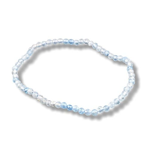 A beaded stretch bracelet made of light blue and clear faceted beads, arranged in an oval shape on a white background with a soft drop shadow.