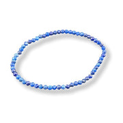 A beaded stretch bracelet made of small faceted blue beads, arranged in a circular shape on a white background with a soft drop shadow.