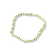 A single beaded stretch bracelet made of small faceted beads in a pale yellow-green color, shown on a plain white background with a soft drop shadow.