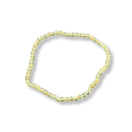 A single beaded stretch bracelet made of small faceted beads in a pale yellow-green color, shown on a plain white background with a soft drop shadow.