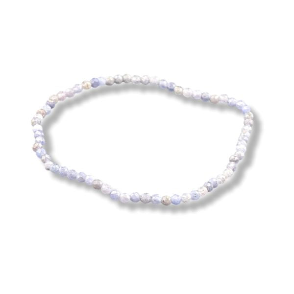 A beaded stretch bracelet made of small round tanzanite beads  light blue, and pale lavender, shown on a white background with a soft drop shadow.