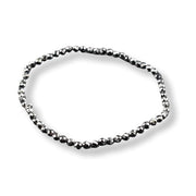 A single beaded bracelet made of small faceted dark metallic beads, arranged in an oval shape on a clean white background.