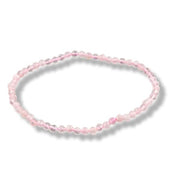 A delicate beaded stretch bracelet made of small, faceted light pink beads, arranged in a circle on a white background with a soft drop shadow.