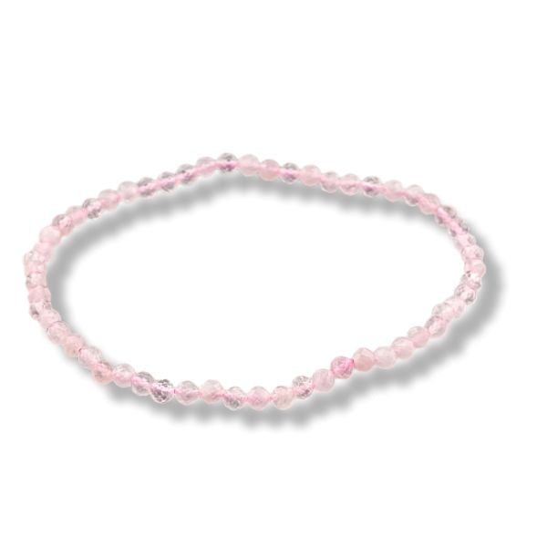 A delicate beaded stretch bracelet made of small, faceted light pink beads, arranged in a circle on a white background with a soft drop shadow.