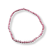 A single strand of faceted pink beads arranged in an oval loop on a clean white background.