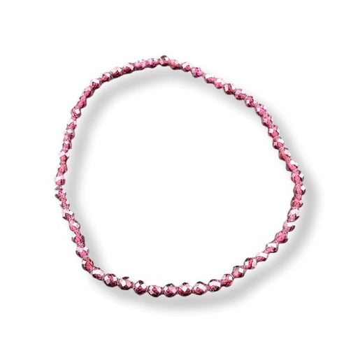 A single strand of faceted pink beads arranged in an oval loop on a clean white background.