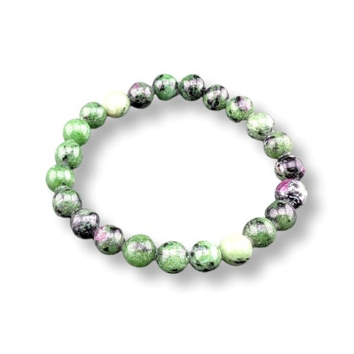 A beaded stretch bracelet made of polished round gemstone beads in green, black, white, and hints of pink, displayed on a clean white background.
