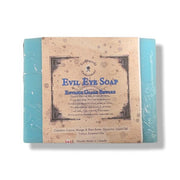 A wrapped bar of Evil Eye Soap, featuring a rustic tan paper label with blue text, on a white background.