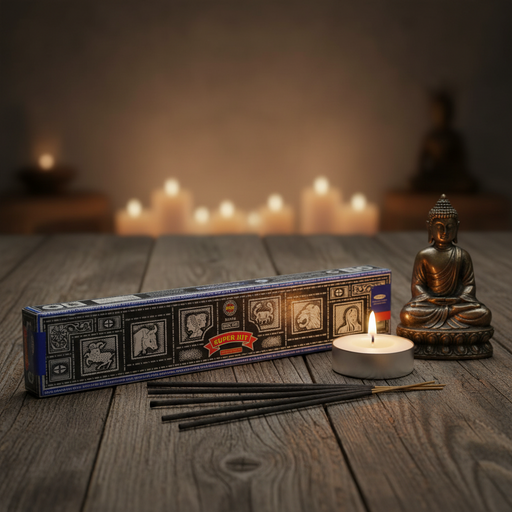 Incense sticks with packaging, lit candle, and Buddha statue on a wooden surface with blurred candles in the background.