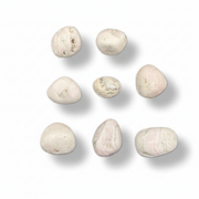 Nine smooth, polished river stones in soft cream, beige, and pale pink hues, arranged in a 3x3 grid on a clean white background with soft drop shadows.