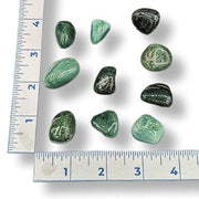Green stones on a white background with a ruler for scale.