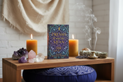 Book titled 'Dreams of What Your Man You' on a wooden table with candles, crystals, and smoke.