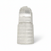 A natural selenite crystal cluster with a stepped, tiered structure, shown on a clean white background.