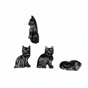Set of four black cat figurines on a white background