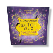 Cover of 'Everyday Witch A to Z Spellbook' by Deborah Blake, featuring a purple and yellow design with mystical symbols and a silhouette of a cat.