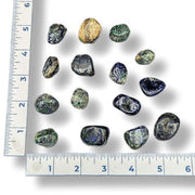Set of colorful stones next to a ruler on a white background