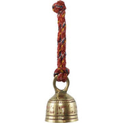 Brass bell with a red rope on a white background