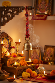 Decorative altar with a bell, flowers, and candles in a warm setting.
