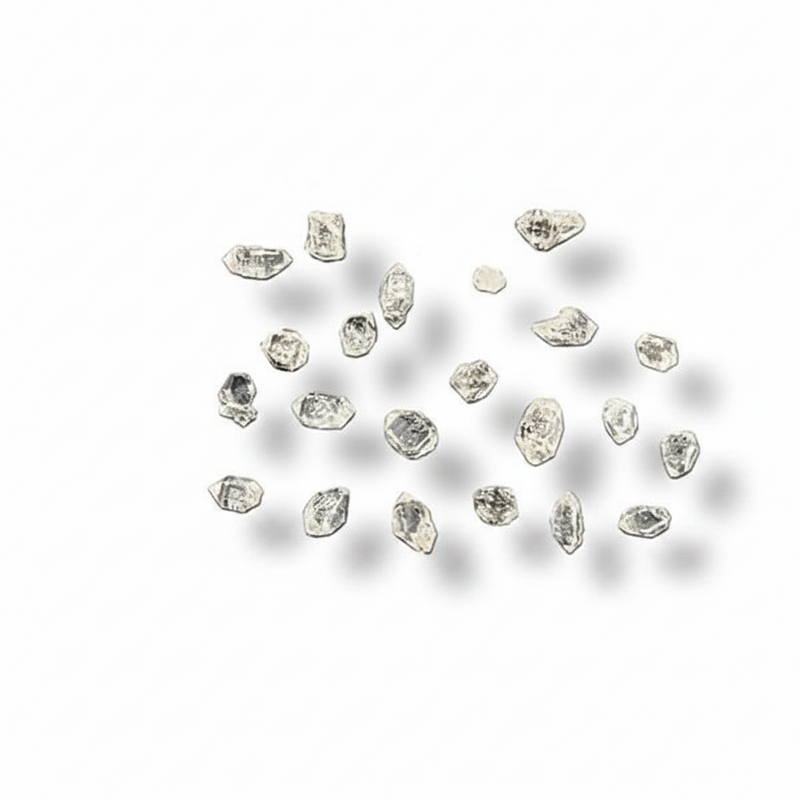 A cluster of small, irregular clear gemstones or crystals arranged on a plain white background with soft drop shadows.