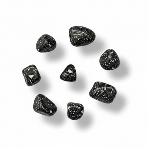 Seven small polished black tumbled stones with white speckles, arranged in a loose circle on a white background with soft drop shadows.