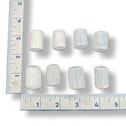 White Selenite rocks  with a ruler for scale on a white background