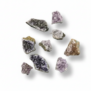 A set of nine raw, rough mineral specimens and crystals in various colors, including purple, gray, brown, black, and gold, arranged on a plain white background with soft drop shadows.