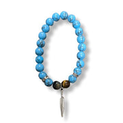 Turquoise beaded bracelet with a feather charm on a white background
