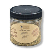 Jar of agrimony with a black lid on a white background
