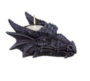 Dragon-shaped candle holder with a lit candle on a white background