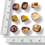 Mookaite polished gemstones on a white background with rulers for scale.