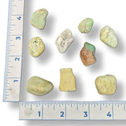 Assorted small rocks on a white background with a ruler for scale.