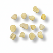 A series of tumbled yellow opal stones of varying sizes, displayed in front of a blue measuring tape for scale.