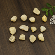Yellow opal tumbled on a wooden table