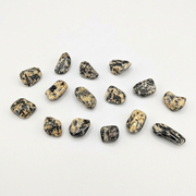 A set of small polished tumbled stones in a natural jasper pattern of black, gray, and beige, arranged on a plain white background.