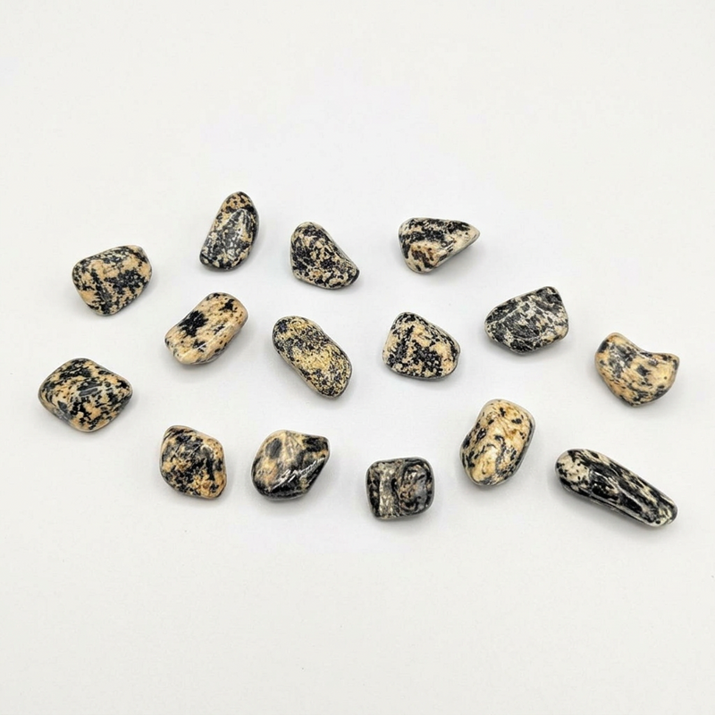A set of small polished tumbled stones in a natural jasper pattern of black, gray, and beige, arranged on a plain white background.