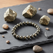 Pyrite bracelet on a dark surface with pyrite crystals