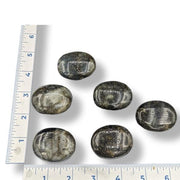 Several polished Labradorite Palmstones of varying sizes placed on a measuring tape for scale.