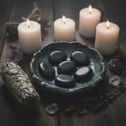 Labradorite palm stone in a dish with candles and sage and herbs around it