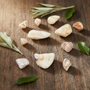 Violet flame opal on a wooden table with herbs in a decorative setting