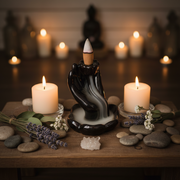Decorative hand incense burner with candles and stones on a wooden surface