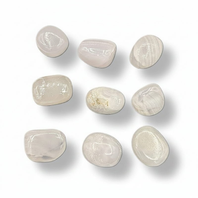 Nine smooth, polished tumbled stones in a light cream to off-pink color, arranged in a 3x3 grid on a white background with soft drop shadows.