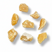 Seven raw, orange calcite crystals scattered on a clean white background with soft drop shadows.
