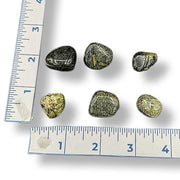 Set of rocks with a ruler for scale on a white background