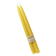 Two yellow candles with a label on a white background