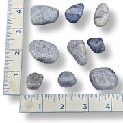 Set of rocks with a ruler for scale on a white background