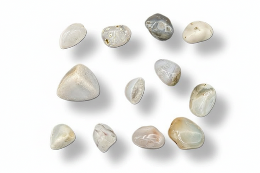 A set of polished, tumbled gemstone in various shapes and natural colors, arranged on a plain white background with soft drop shadows.